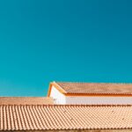 A serene image of terracotta roofs contrasting with a vibrant blue sky, showcasing architectural simplicity.